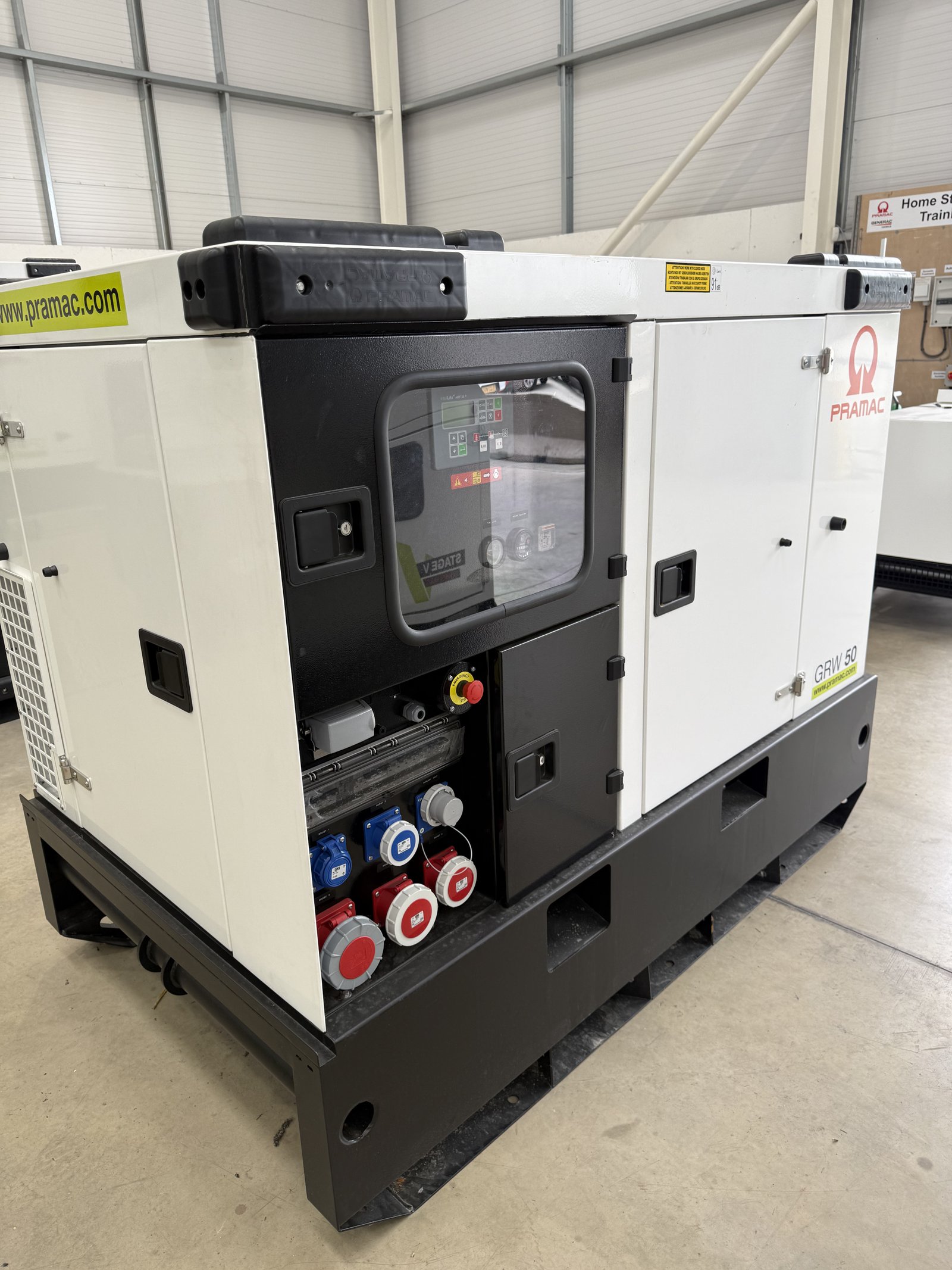 Three-quarter front view of a PRAMAC GSW 50 silent diesel generator housed in a white weatherproof acoustic canopy. The generator features a digital control panel with viewing window, multipl