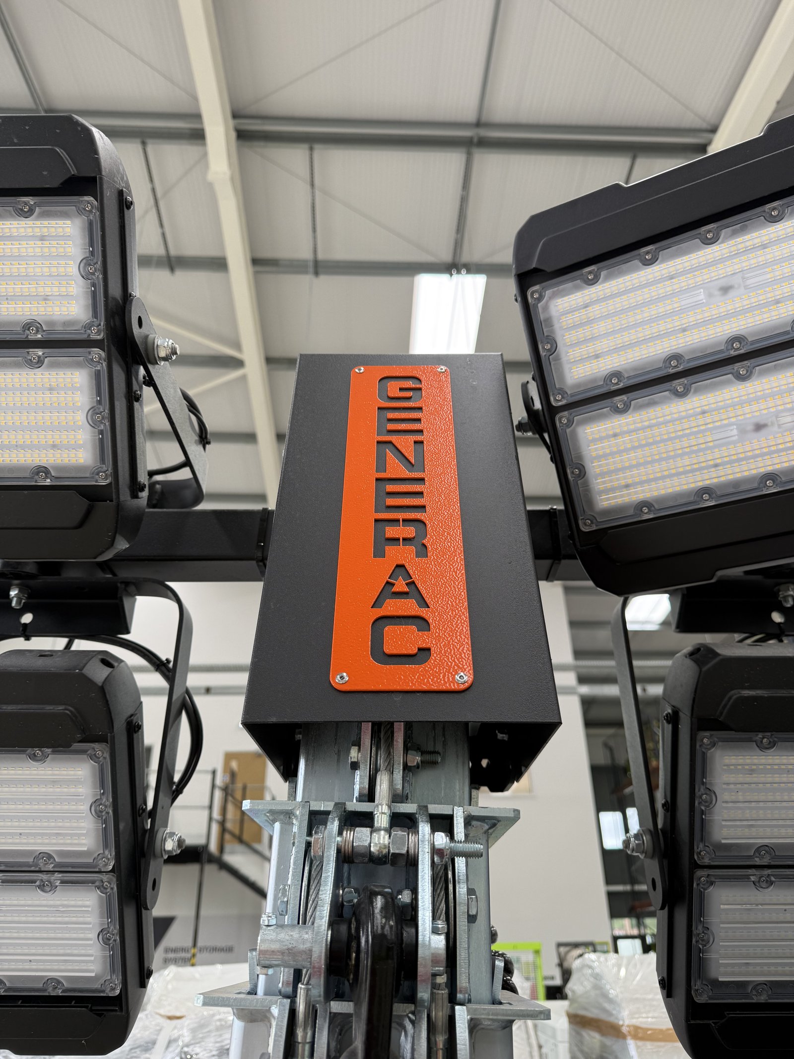 Close-up view of the mast assembly on a Generac Mobile LED lighting tower, featuring four high-output adjustable LED floodlights mounted around a telescopic mast. The image highlights the rob